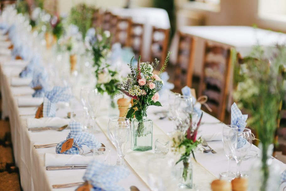 Elegant dining setup with floral centerpieces and neatly arranged place settings.