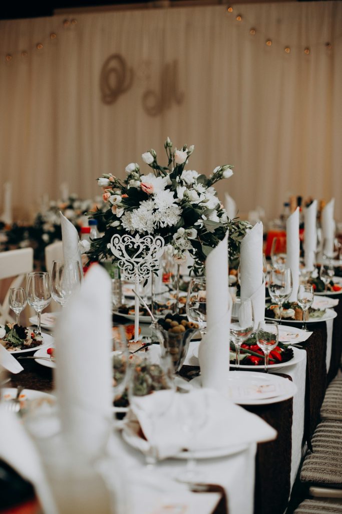 Elegant dining setup with floral centerpiece and lit candles on a festively decorated table.