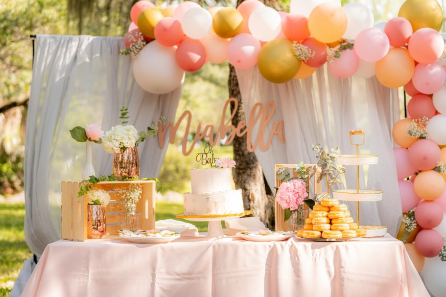 Decorative party setup with a cake, flowers, and colorful balloons.